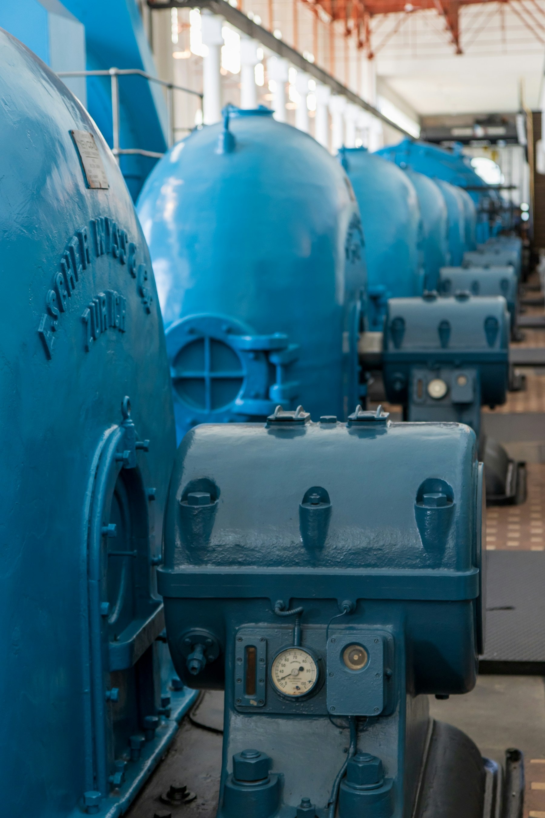 Une rangée de générateurs industriels bleus dans une salle des machines